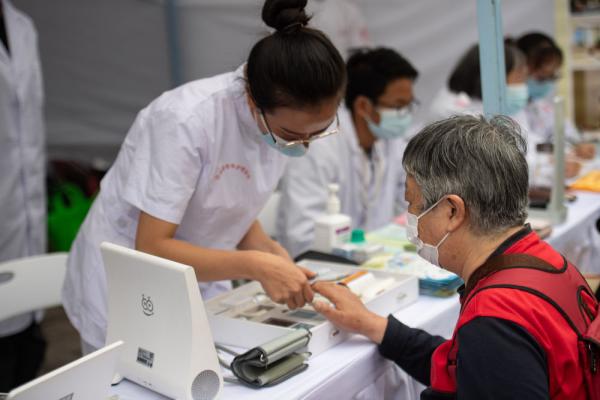 10月10日，医护人员为到场参与活动的老人进行简单体检。